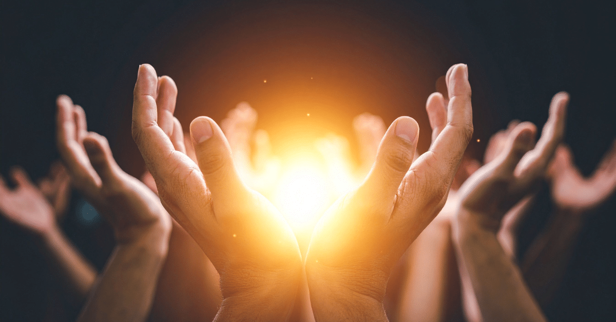 Mehrere geöffnete Hände sind dem Licht einer warm leuchtenden Sonne entgegengestreckt. Das Bild vermittelt Gemeinschaft, Hoffnung und innere Kraft.